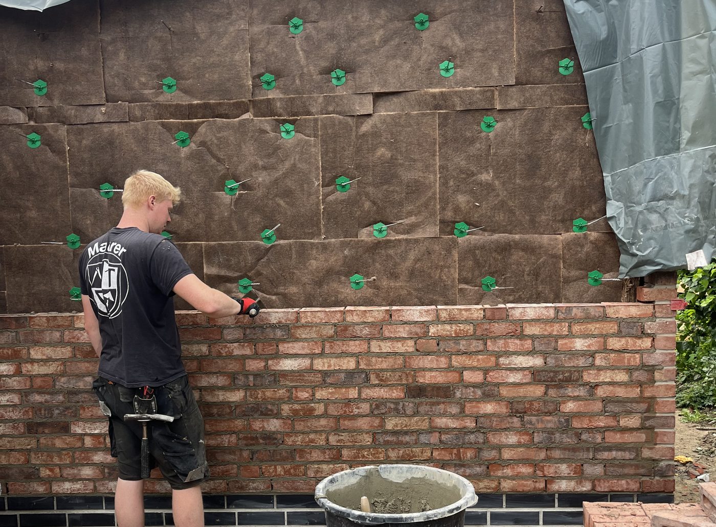 Maurer setzt die Klinkerfassade vor der gedämmten Außenwand