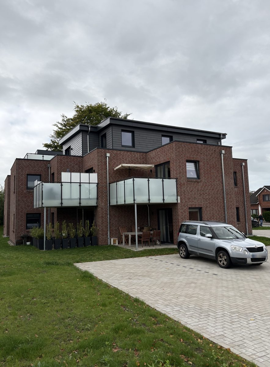 Fertiggestelltes Mehrfamilienhaus mit gepflasterter Hoffläche