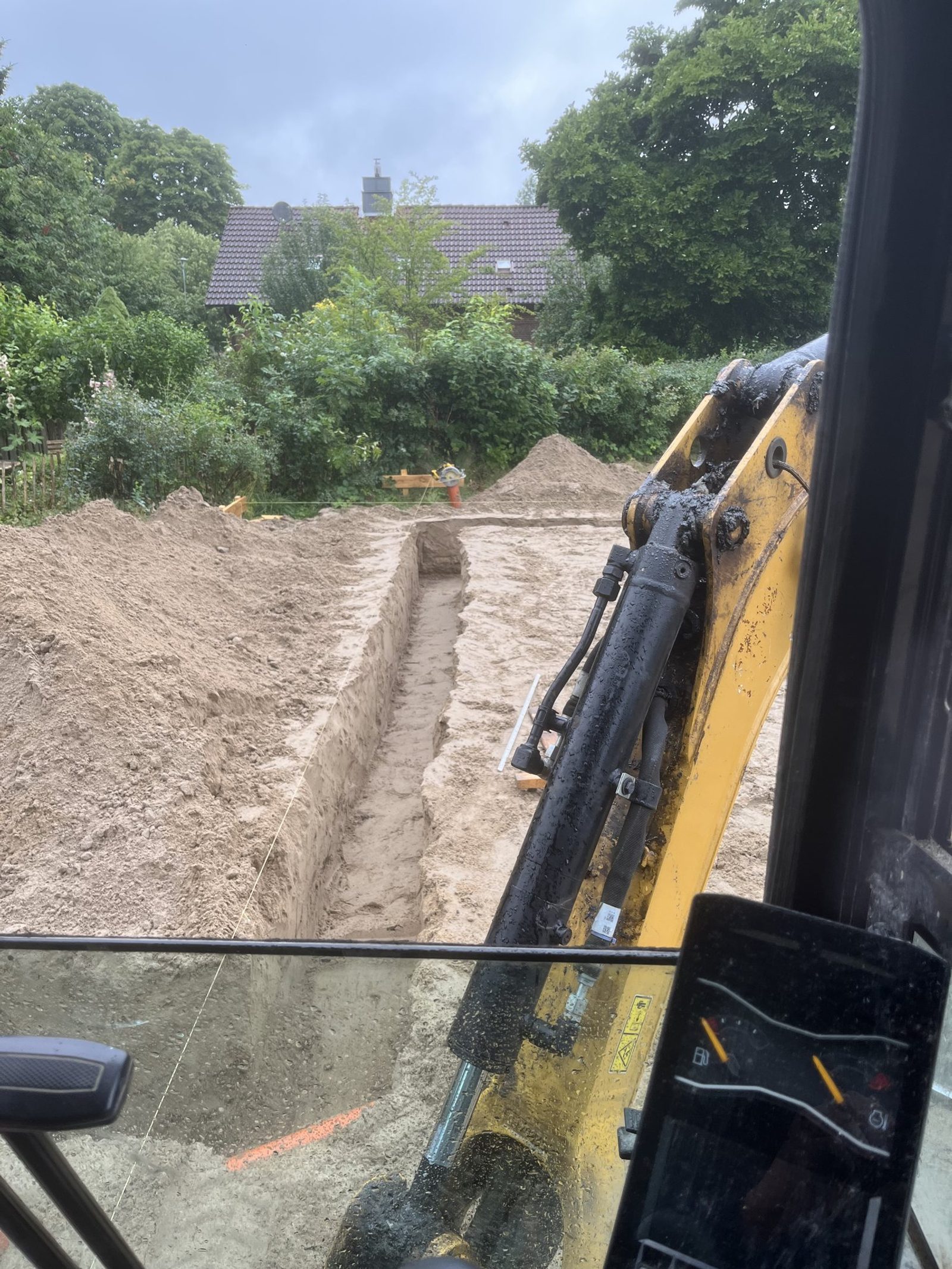 Bagger hebt den Graben für die Bodenplatte aus