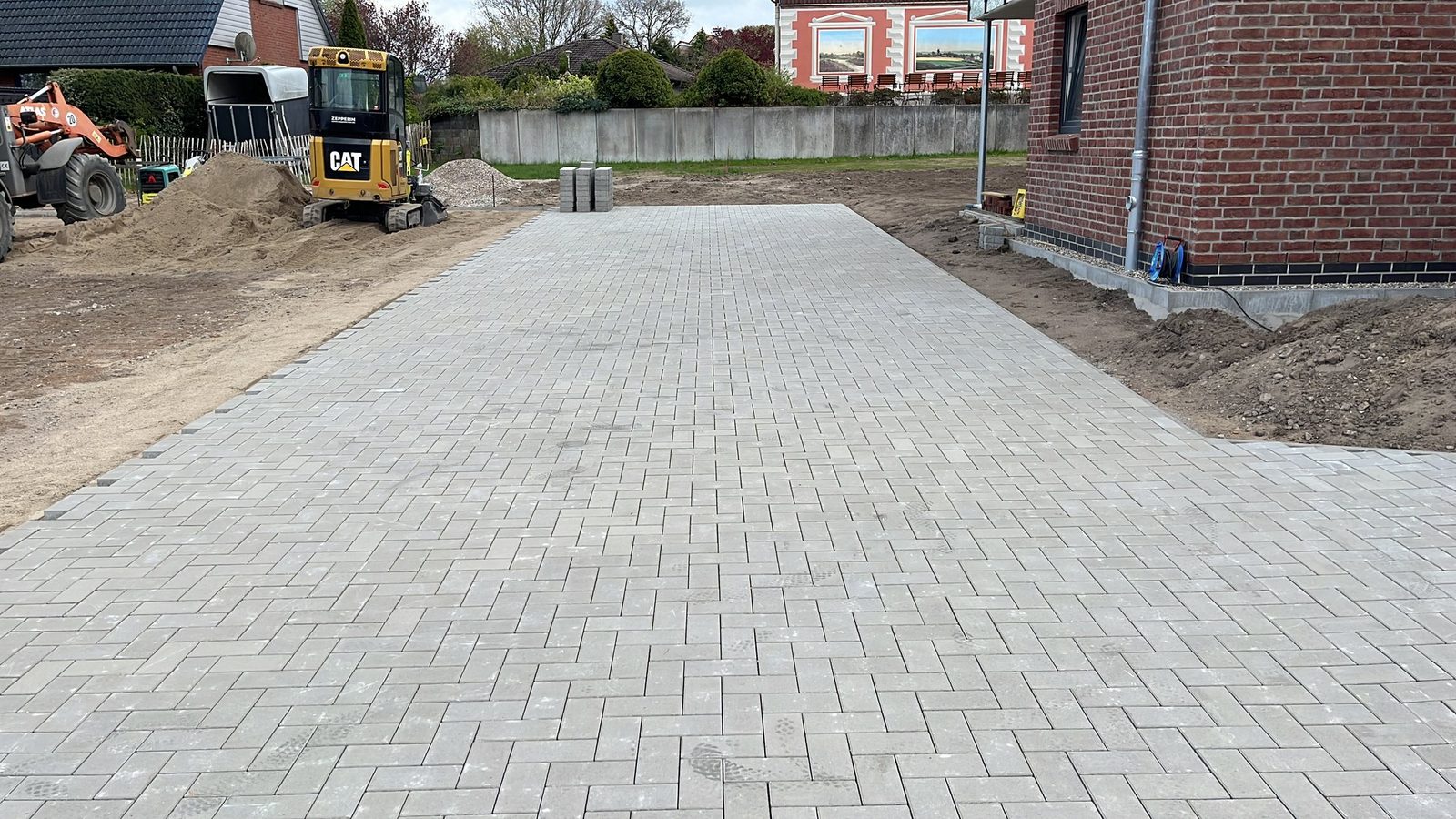 Fertig gepflasterte Zufahrt entlang des Gebäudes